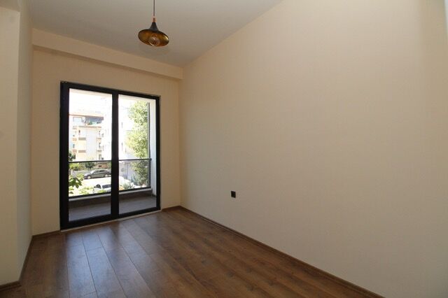 Bright empty room with large window and wooden flooring in Yalova property.