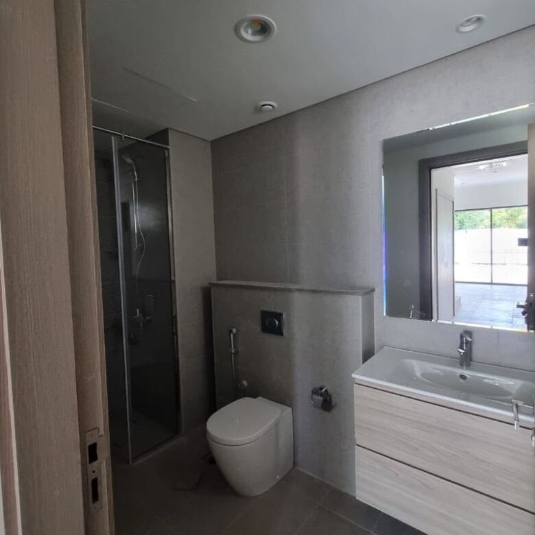 Modern Dubai bathroom with shower, toilet, and sink in a premium property.