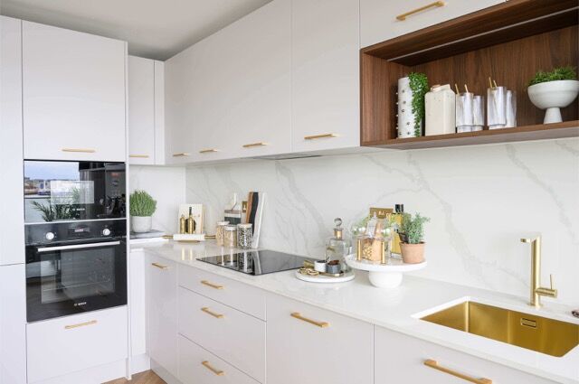 Elegant 2-Bedroom Apartment kitchen in Woolwich, London, featuring white cabinetry, gold fixtures, a.
