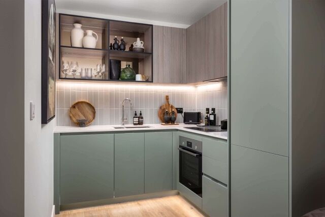 Modern kitchen in Southall apartment with sleek cabinetry and open shelving.
