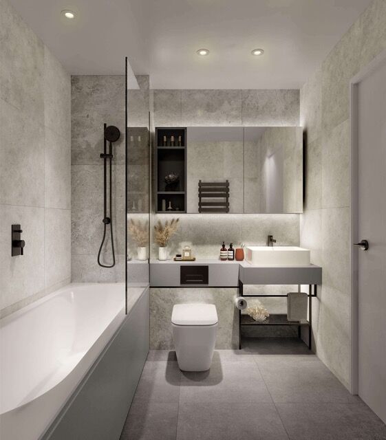 Bright, contemporary bathroom with a bathtub, toilet, and sleek vanity in a stylish apartment in Fin.