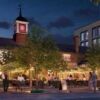 Beautiful evening scene of Wandsworth's historic town square with illuminated trees and lively socia.