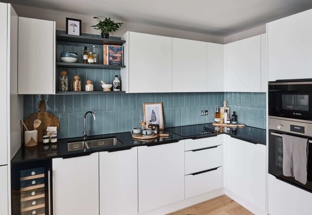 Bright, modern kitchen with white cabinets and blue tiled backsplash in a spacious Plumstead, London.