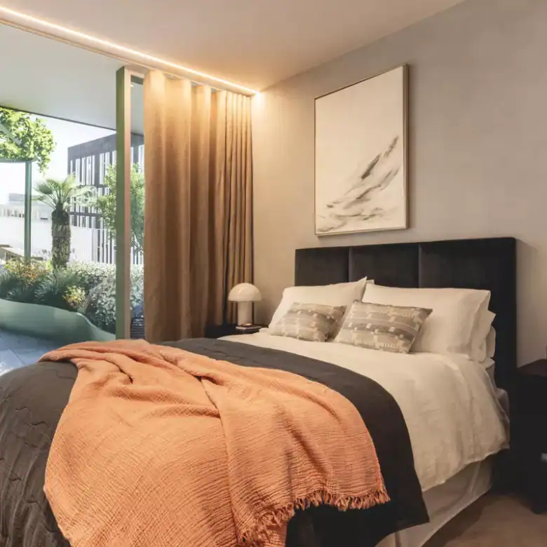 Luxury apartment bedroom with modern decor and large windows.