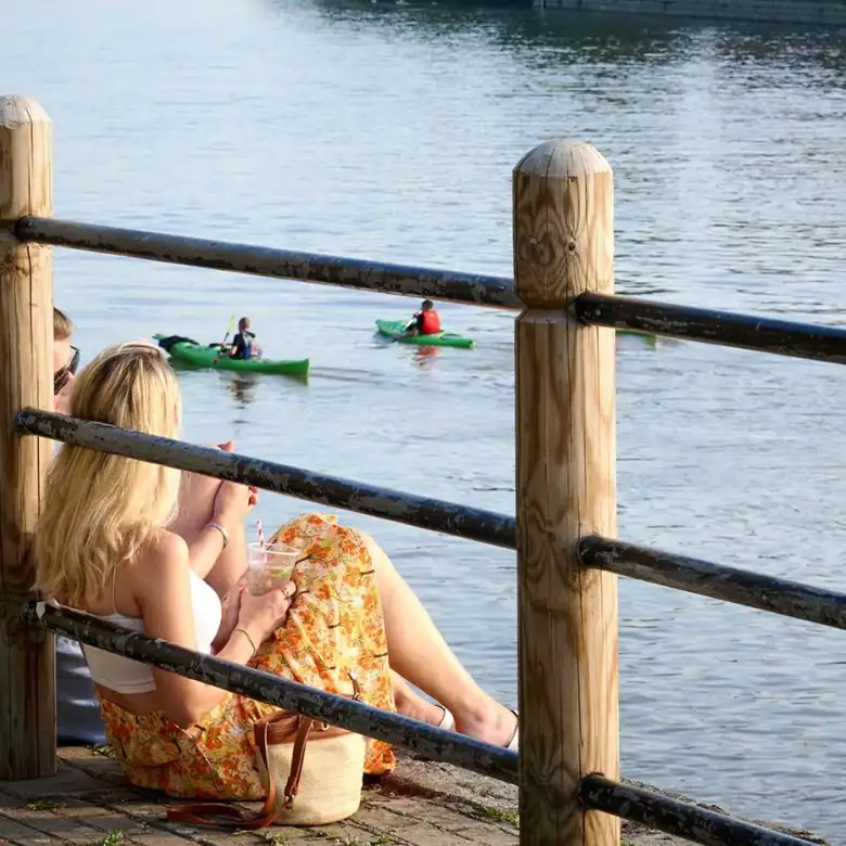 Woman relaxing by the river in Fulham, enjoying scenic views and peaceful surroundings.