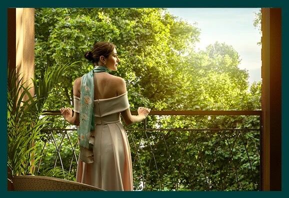Woman overlooking lush green Marylebone neighborhood from balcony.