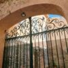Elegant wrought iron gate with intricate scrollwork and a welcoming archway.