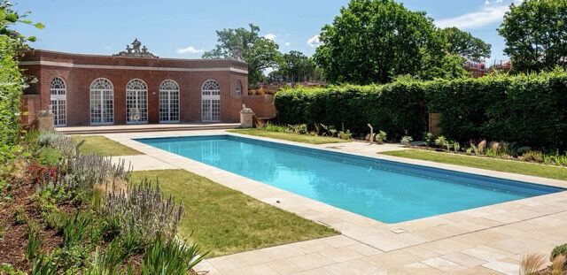 Beautiful private pool at luxury house in Enfield with lush garden surroundings.