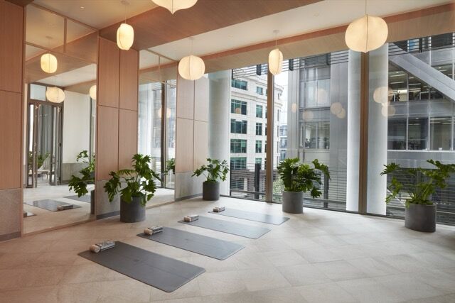 Modern yoga studio with city skyline views and natural light in Pan Pacific London.