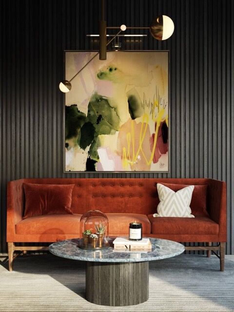 Elegant interior featuring a coral sofa, abstract art, and contemporary lighting.