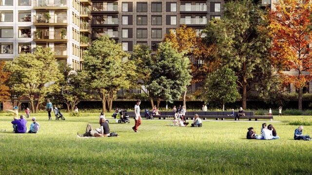 Riverside park with lush green trees and people relaxing in East London.