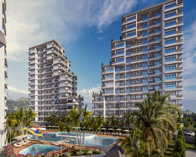 Modern high-rise apartments in Mersin with sea views, lush gardens, and swimming pools.