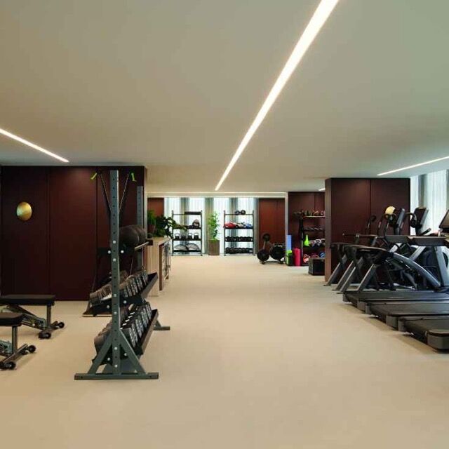 Luxury gym with modern equipment and panoramic city views at Pan Pacific London.