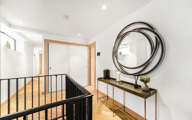 Contemporary hallway with mirror art and elegant decor in Marylebone, London.