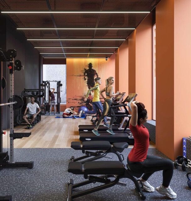 Modern gym interior with people exercising in Manchester apartments.