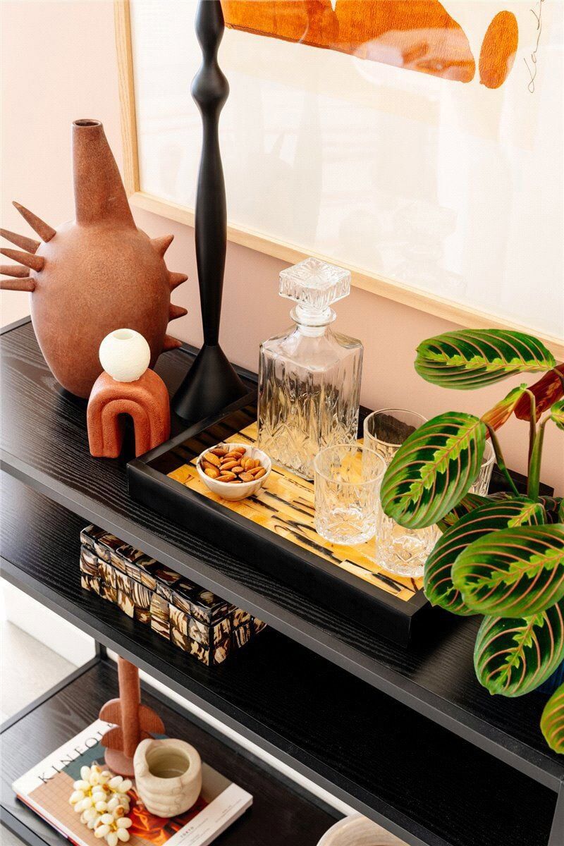 Stylish home decor with vases, plants, and decorative items on a black console table.