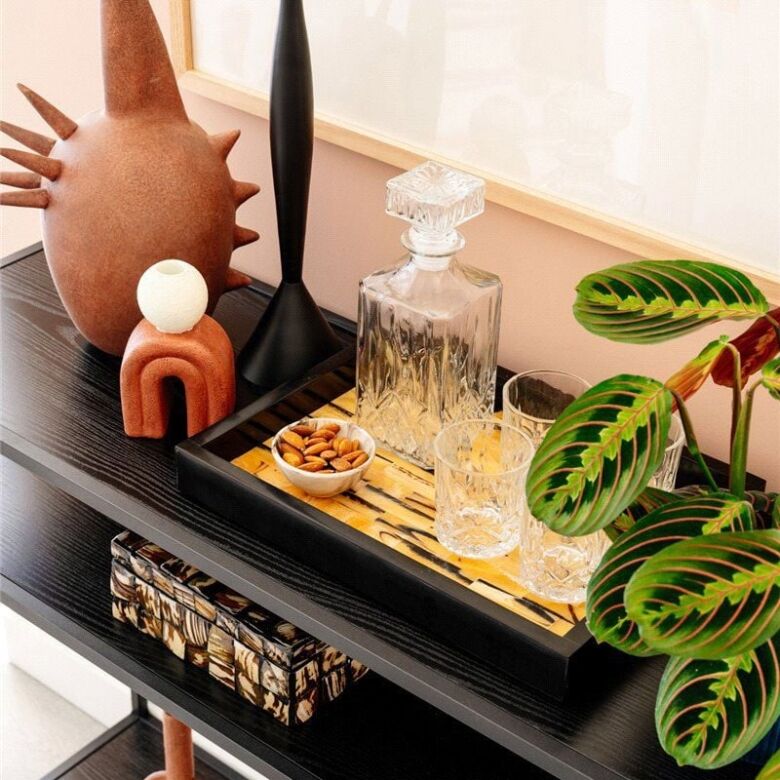 Stylish home decor with vases, plants, and decorative items on a black console table.