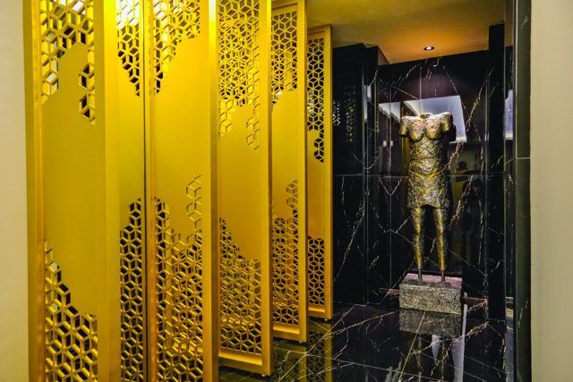 Bright yellow decorative room divider with intricate cut-out patterns.
