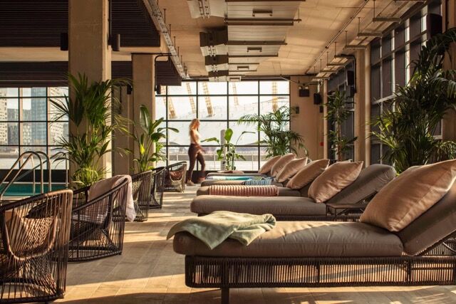 Riverside lounge area with modern furniture and large windows in London.