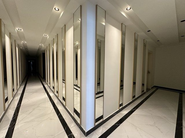 Spacious corridor with mirrors in a modern apartment building in Alanya's Guller Pınarı neighborhood.