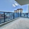 Spacious balcony of a modern 1+1 apartment with pool access, offering stunning city views and outdoo.