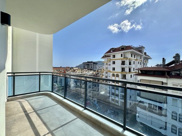 Modern 1+1 apartment featuring a spacious balcony with pool views, perfect for comfortable urban liv.