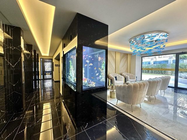Elegant 1+1 apartment featuring a large aquarium, modern decor, and a spacious living area with balc.