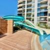 Contemporary flats in Mersin Tece with pool and water slide near the beach.