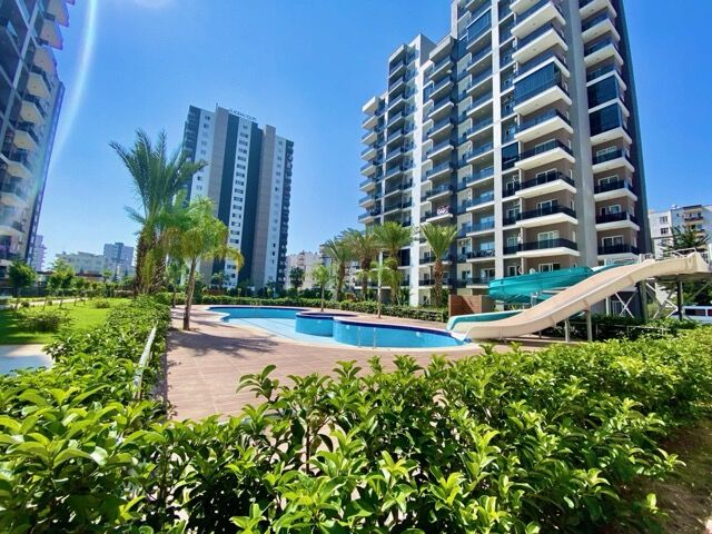 Contemporary apartment complex in Mersin with pool, garden, and nearby beach access.