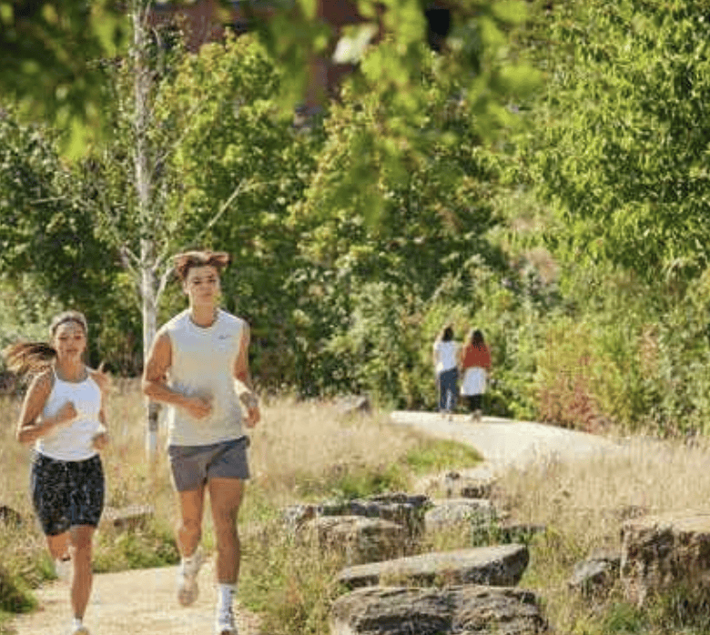 Two women jogging in a green park in Greenwich, ideal for investment and high rental yields.