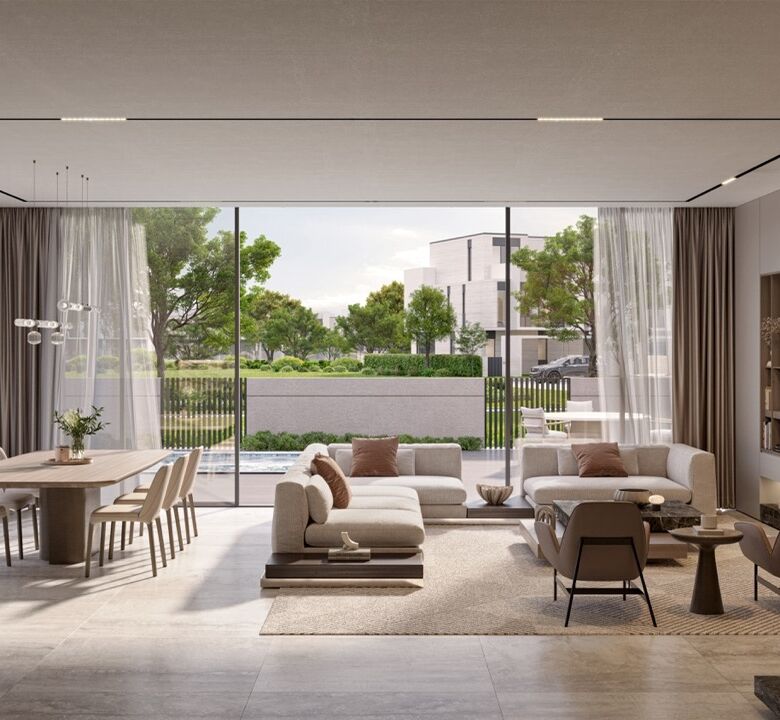 Elegant living room with large glass windows overlooking lush greenery in Dubai.