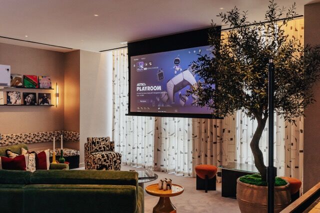 Stylish living room with large screen, cozy seating, and indoor plants in One Nine Elms, London.