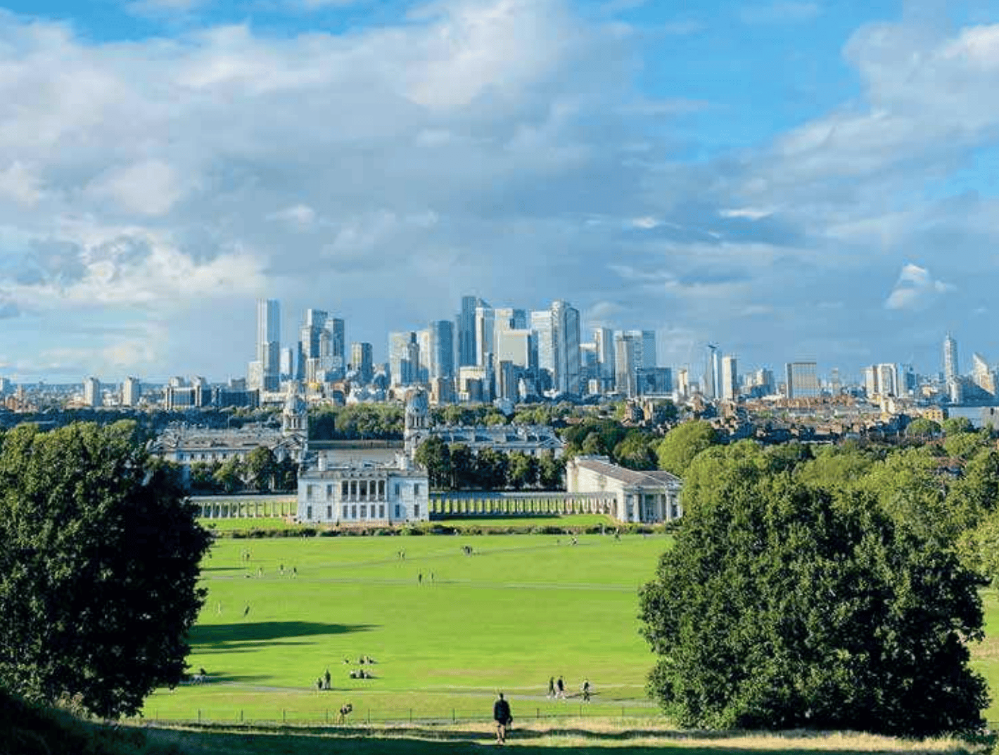 View of Greenwich Park with London city skyline in the background.