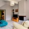 Bright living room featuring a fireplace, white sofa, and vibrant blue armchair in a charming home s.