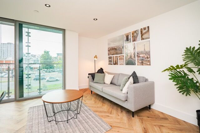 Modern Sheffield apartment living room with balcony and city views.