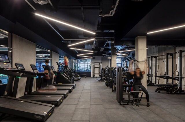 Gym interior featuring state-of-the-art workout machines and modern lighting for an energetic fitnes.