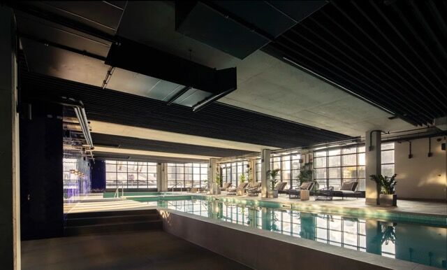 Luxurious indoor swimming pool at Riverside Residences, London. Modern design with large windows and.