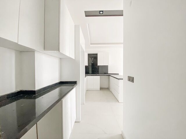 Bright modern kitchen with white cabinets and black countertops in Kargıcak, Alanya.