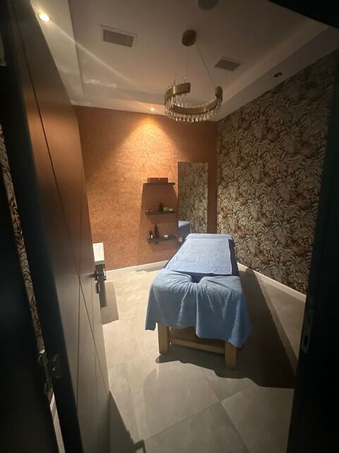 Spacious massage room with relaxing ambiance and elegant decor.