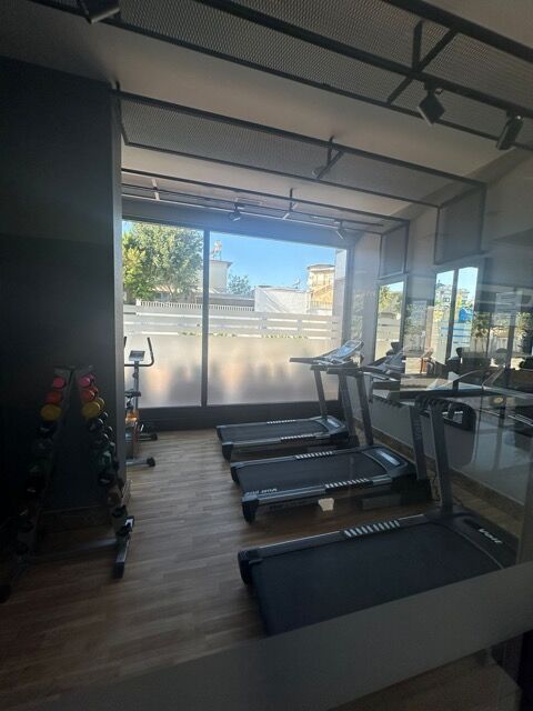 Bright gym area with treadmills and large windows overlooking outdoor scenery.