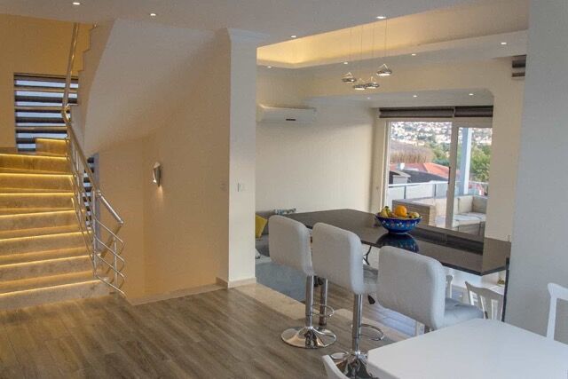 Spacious living room with contemporary furniture, open-plan design, and large windows overlooking th.