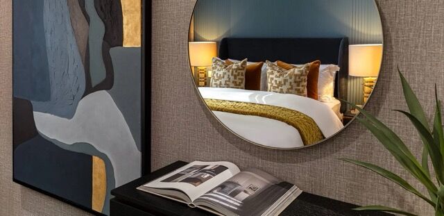 Modern bedroom with stylish decor and a large mirror in North London.