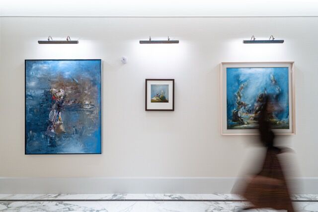 Modern art gallery showcasing stunning blue-themed paintings in a bright, contemporary space.