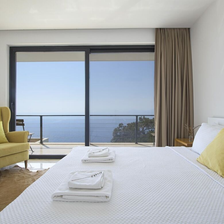 Spacious bedroom featuring a large window overlooking the sea in a luxurious Fethiye villa. Perfect.