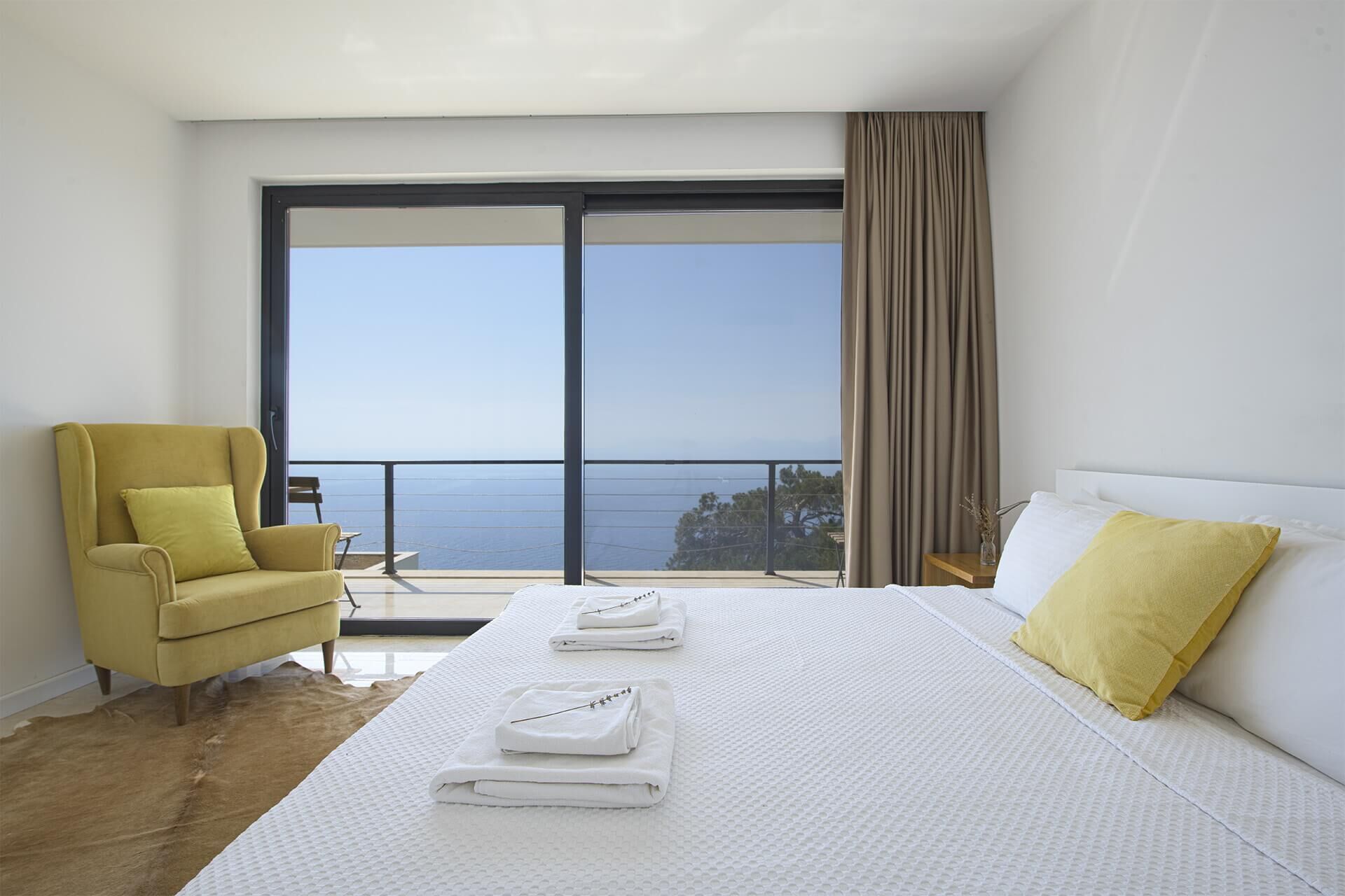 Spacious bedroom featuring a large window overlooking the sea in a luxurious Fethiye villa. Perfect.