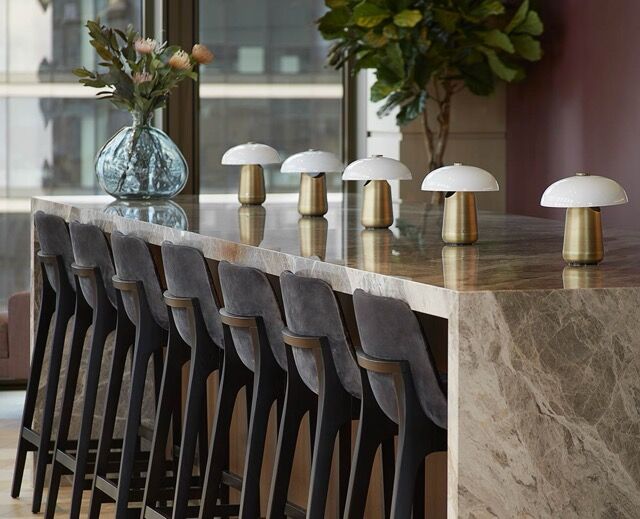 Elegant interior view of a modern bar counter with stylish lamps and floral decor.