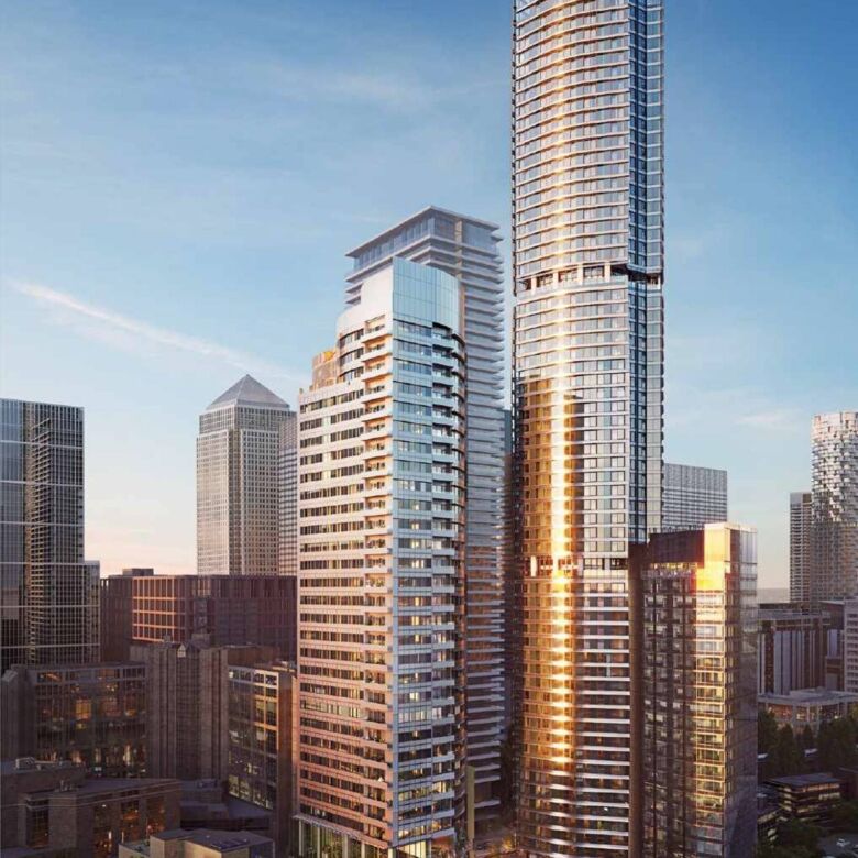 Modern high-rise buildings in Canary Wharf with glass facades reflecting sunset light.