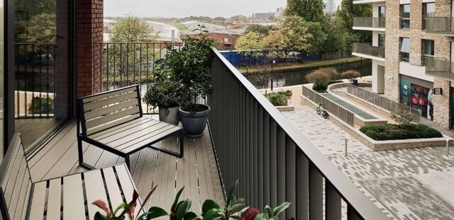 Balcony view of Wembley residences overlooking river and cityscape. Modern outdoor space with seatin.
