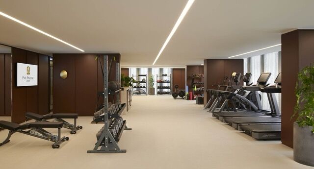 Luxury fitness center with modern equipment and natural light at Pan Pacific London.