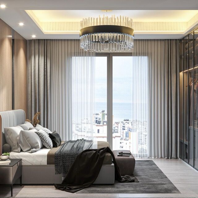 Stylish apartment bedroom with sea view near Mersin beach, featuring elegant decor and large windows.